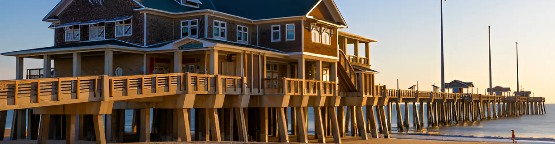 A shingled pier house raised on pilings at the head of a long wooden fishing pier